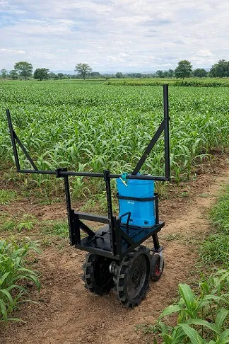 Rear view of a compact Karagre robot moving through a farm row